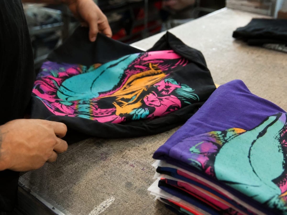 Inspecting a fresh run of printed shirts